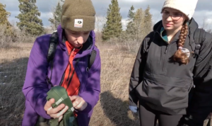 Alysha Henry showing a trail camera to a student